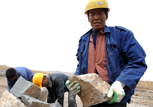 5月1日,一名建筑工人在內(nèi)蒙古赤峰市松山區(qū)三座店水利樞紐建設(shè)工地上搬運(yùn)護(hù)壩石料。新華社記者 張領(lǐng) 攝