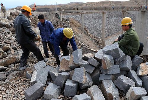 5月1日,建筑工人在內(nèi)蒙古赤峰市松山區(qū)三座店水利樞紐建設(shè)工地上搬運(yùn)護(hù)壩石料。新華社記者 張領(lǐng) 攝