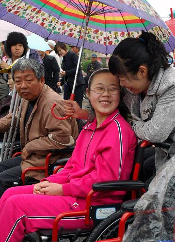 5月17日,一名女孩坐在獲贈(zèng)的輪椅上和家人交談。當(dāng)日是“全國(guó)助殘日”,黑龍江海林市舉行“扶殘助行、共建和諧”輪椅捐贈(zèng)活動(dòng),百名殘疾人士獲贈(zèng)輪椅。新華社發(fā)(張春祥 攝)