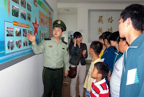 5月17日,民警帶領殘障小朋友參觀警營榮譽室。當日是第19個“全國助殘日”,山東威海青漁灘邊防派出所民警走進榮成市特殊教育學校,開展“關愛殘障兒童,發(fā)展特殊教育”主題活動,向部分學生捐贈價值1000余元的學習用品和益智、勵志類圖書。隨后,民警還邀請該校部分優(yōu)秀殘障兒童代表到邊防警營參觀內務設置和榮譽室,體驗穿戴警務裝備,并和孩子們開展了“二人三退跑”“蒙眼擊球”等益智游戲。新華社記者 朱崢 攝