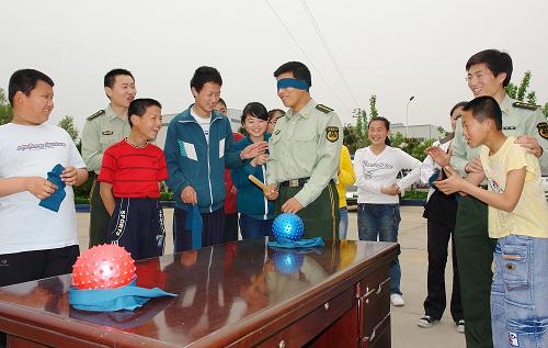 5月17日,邊防民警帶領殘障小朋友做“蒙眼擊球”游戲。新華社記者 朱崢 攝