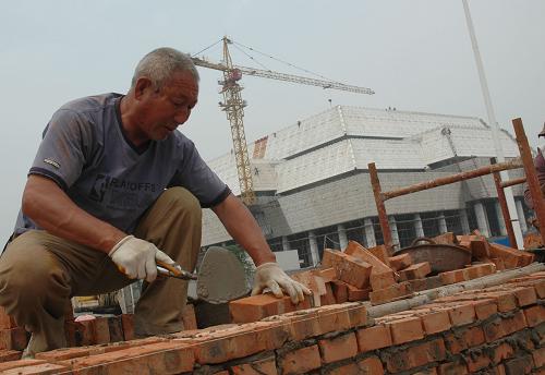 5月16日,建筑工人為建設中的河南安陽中國文字博物館砌圍墻。 新華社發(fā)(常中正 攝)