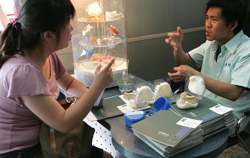 5月17日,北京贏冠義齒加工有限責(zé)任公司的殘疾員工(右),在招聘會上用手語向殘疾大學(xué)生介紹招聘崗位。當日是第19個“全國助殘日”,北京市舉辦第八屆殘疾大學(xué)生專場招聘會,數(shù)十家用人單位提供了318個工作崗位,吸引600多名應(yīng)、往屆殘疾大學(xué)畢業(yè)生前來應(yīng)聘。新華社發(fā)(趙冰 攝)
