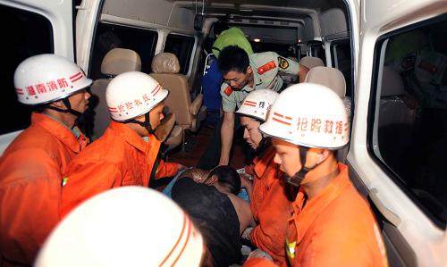 5月17日,消防官兵正把一名傷者送上救護(hù)車。新華社記者 李尕 攝