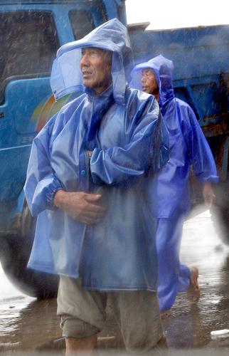 8月9日,浙江省蒼南縣霞關鎮(zhèn)兩位漁民冒著風雨行進。新華社記者 王定昶 攝