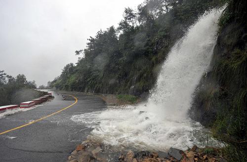 8月9日,強(qiáng)降雨帶來的山洪正沖擊浙江省溫州市蒼南縣礬山鎮(zhèn)到觀美鎮(zhèn)的一段公路。新華社記者 王定昶 攝
