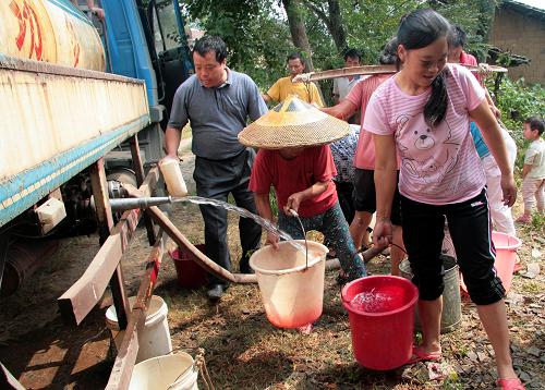 9月4日,在湖南省邵陽縣黃荊鄉(xiāng)毛鋪村,政府調(diào)來車輛為村民送水。受持續(xù)旱情影響,邵陽縣農(nóng)作物遭受不同程度的旱情,部分村組人畜飲用水發(fā)生困難,當(dāng)?shù)攸S荊鄉(xiāng)毛鋪、南山等村居民要到1公里外取水。當(dāng)?shù)馗骷壵壳耙讶ν度肟购稻葹?zāi),力保人畜飲水安全。新華社發(fā)(李愛民 攝)