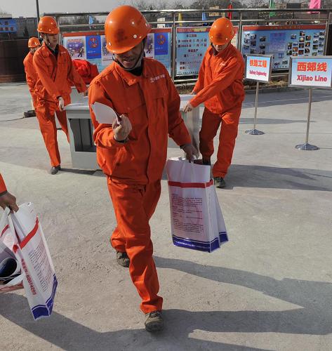 2月2日,北京一處施工工地的工人領(lǐng)到有關(guān)安全燃放煙花爆竹的宣傳單。新華社記者 李文 攝