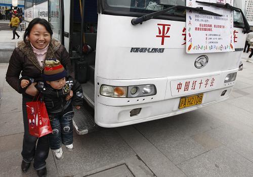 2月3日,即將返回安徽老家的叩芝抱著自己的兒子走下采血車。在登上火車前一個(gè)小時(shí),她把400毫升血液連同自己的愛(ài)心留在了上海。新華社記者 裴鑫 攝