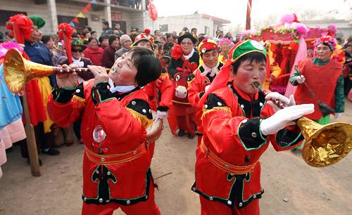 2月5日,村民在表演當(dāng)?shù)孛袼滋厣?jié)目“抬花轎”。新華社發(fā)(薛俊 攝)