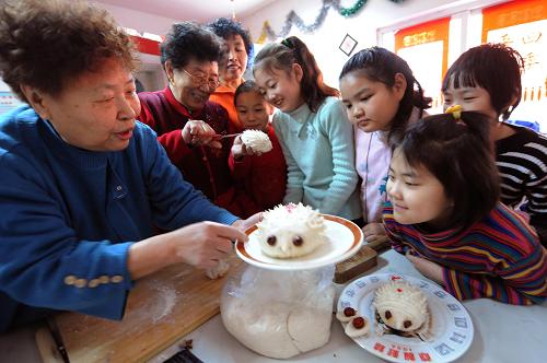 2月5日,天津綿陽道社區(qū)的老奶奶們?cè)诮o小朋友講授面食制作技藝。新華社記者 劉海峰 攝