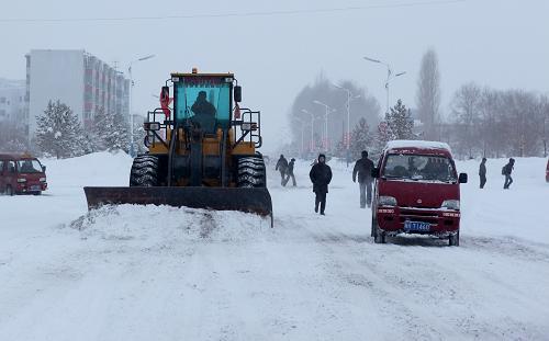 2月5日,富蘊(yùn)縣交通局的工程機(jī)械在街道上清理積雪。新華社發(fā)(丁寧 攝)