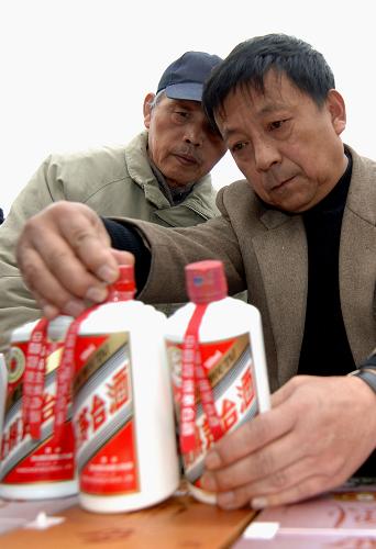 3月15日,在西安市新城廣場(chǎng),消費(fèi)者在了解識(shí)別假酒的竅門。新華社記者 丁海濤 攝