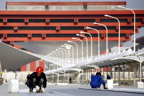 3月17日,一名工人正在上海世博會(huì)浦東園區(qū)的景觀步道上鋪設(shè)地坪。新華社記者 裴鑫 攝