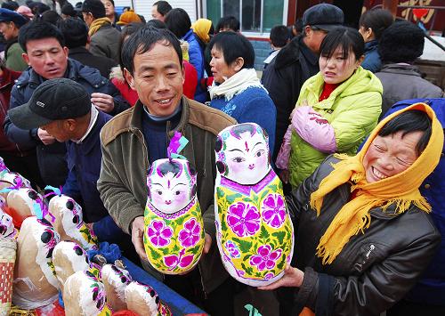 3月17日,人們在山東濱州市惠民縣皂戶李鄉(xiāng)火把李村的“泥娃娃廟會”上選購泥娃娃。新華社發(fā)(董乃德 攝)