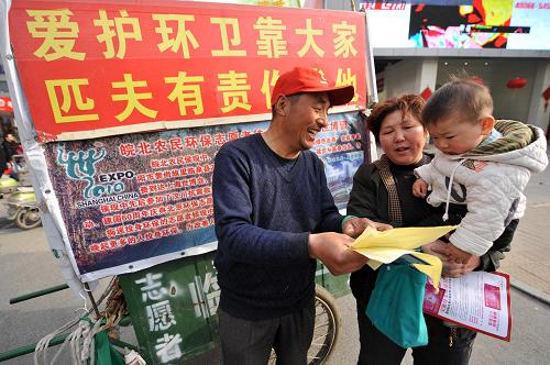 3月17日,環(huán)保志愿者侯現(xiàn)中(左)在合肥街頭向市民介紹上海世博會、宣傳環(huán)保理念。新華社發(fā)(項春雷 攝)