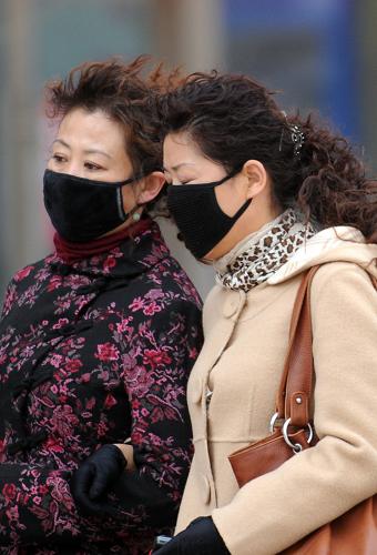 3月19日,戴著口罩的西寧市民行進在風(fēng)沙之中。新華社記者 侯德強 攝
