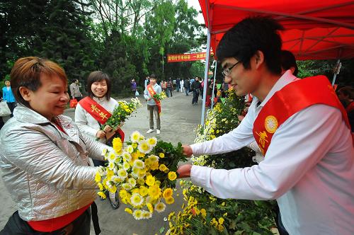 4月4日,在廣西梧州仙風(fēng)山墓園的“鮮花換紙錢(qián)”免費(fèi)兌換處,志愿者將鮮花遞給前來(lái)掃墓的市民。新華社發(fā)(何鎏 攝)