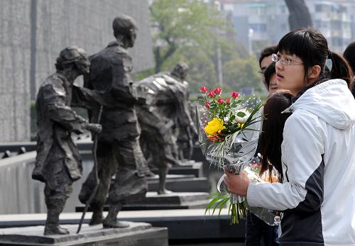 4月4日,幾名大學(xué)生在侵華日軍南京大屠殺遇難同胞紀(jì)念館群雕前憑吊遇難同胞。清明節(jié)前夕,成千上萬的南京市民、學(xué)生和外地游人來到侵華日軍南京大屠殺遇難同胞紀(jì)念館參觀祭奠,憑吊被侵華日軍殺害的同胞。新華社記者 孫參 攝