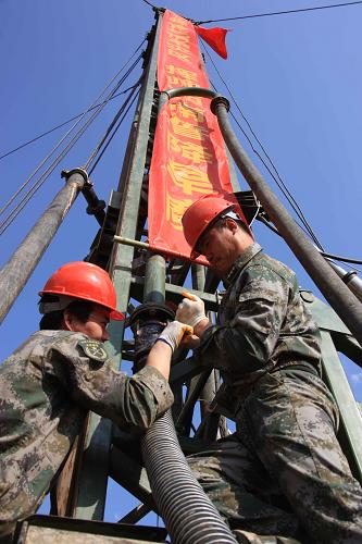 4月4日,北京軍區(qū)給水工程團(tuán)鉆井4連官兵奮戰(zhàn)在鉆井平臺上。北京軍區(qū)給水工程團(tuán)4月1日抵達(dá)云南后,隨即開赴旱災(zāi)最重的石林縣、祿勸縣,開展找水打井作業(yè)。數(shù)天來,子弟兵支援西南地區(qū)抗旱救災(zāi),把保民生作為首要任務(wù),重點(diǎn)解決群眾吃水難問題。新華社記者 王建民 攝