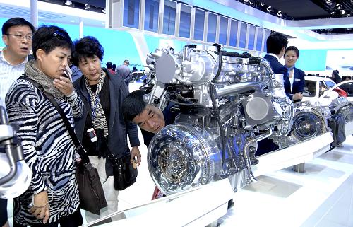 4月27日,北京車展上,幾位觀眾在觀看廠家展出的發(fā)動機模型。新華社發(fā) (張宇 攝)