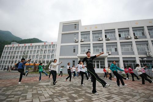 5月12日,陜西略陽縣天津職教中心的學(xué)生在教學(xué)樓前練習(xí)健美操。據(jù)了解,汶川地震發(fā)生后,漢中市在天津?qū)谥г蜕鐣?huì)各界大力支持下,累計(jì)籌措災(zāi)后重建資金超過151億元,扎實(shí)推進(jìn)恢復(fù)重建并取得了重大成效。天津?qū)谥г畬帍?qiáng)縣和略陽縣的9大類295個(gè)重建項(xiàng)目全部竣工,完成投資35.84億元,其中天津市投入援建資金20.4億元。在汶川地震中,漢中市11縣(區(qū))不同程度受災(zāi),受災(zāi)人口246萬人,因?yàn)?zāi)遇難48人,受傷1601人,經(jīng)濟(jì)損失達(dá)108億元。新華社發(fā)(王偉 攝)