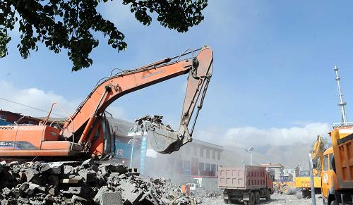5月19日,各種機械在結古鎮(zhèn)街道兩旁進行廢墟清運作業(yè)。新華社記者 侯德強 攝