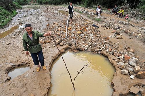 5月20日,在廣西融安縣雅瑤鄉(xiāng)大琴村鳥龍屯,大水將一處稻田沖出一米多深的大坑。新華社記者 李斌 攝
