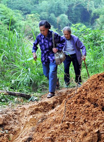 5月20日,廣西融安縣雅瑤鄉(xiāng)大琴村,由于道路損毀,村民步行出村。新華社記者 李斌 攝