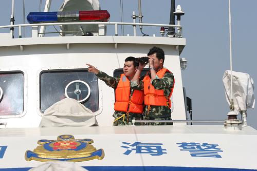 5月20日,山東海警官兵在執(zhí)法船艇上巡視海上可疑漁船。新華社發(fā)(于啟波 攝)