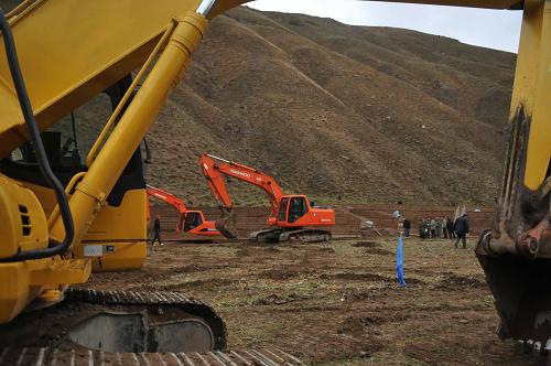 5月21日,在玉樹綠色農(nóng)業(yè)基地的一個工地上,挖掘機正在作業(yè)。當(dāng)日,玉樹災(zāi)后重建綠色農(nóng)業(yè)基地項目開工儀式在結(jié)古鎮(zhèn)東風(fēng)村舉行。據(jù)了解,該項目共計投資4200萬元,預(yù)計6月15日前在全州完成1923棟日光節(jié)能溫室的修建。這些溫室投入生產(chǎn)后,所有在玉樹的人都能吃上新鮮蔬菜。新華社記者 吳光于 攝