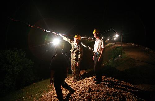 峽江供電公司的工作人員在對堤壩臨時照明用電設施進行巡視檢查(6月25日攝)。新華社發(fā)(馬克雄 攝)