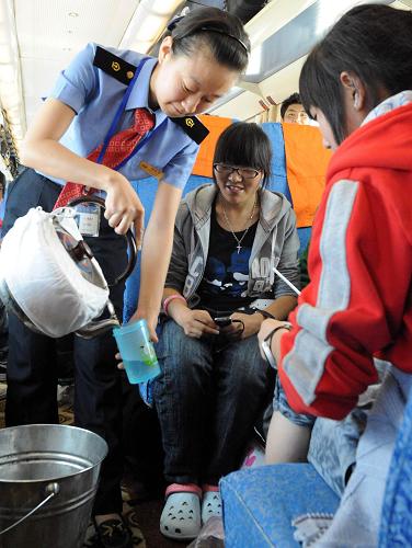 7月4日,被藏族群眾稱為“格桑花”的列車員魏若思在唐古拉段為旅客送水。從2006年7月1日青藏鐵路全線通車到今年7月1日,北京鐵路局北京客運(yùn)段京藏車隊(duì)4年中安全運(yùn)行1168萬公里,運(yùn)送旅客438萬人次,從未發(fā)生一起因安全和服務(wù)而起的旅客投訴事件。北京客運(yùn)段京藏車隊(duì)所值乘的T27/28次列車,從北京至拉薩全程4064公里,單程運(yùn)行約46小時(shí)。在青藏鐵路線上,京藏車隊(duì)15個(gè)班組、500多名乘務(wù)人員克服高寒缺氧等困難,熱情為廣大旅客服務(wù),先后推出了漢、藏、英三種語言服務(wù),10多種藏、回菜肴以及介紹高原風(fēng)光,向旅客發(fā)放服務(wù)新名片等方面的13項(xiàng)服務(wù)內(nèi)容。在這條世界上海拔最高的鐵路上,大多數(shù)的乘務(wù)人員跟車整整跑了4年。4年跑了100多趟,總計(jì)上萬小時(shí),架起民族團(tuán)結(jié)的橋梁。新華社記 唐召明 攝