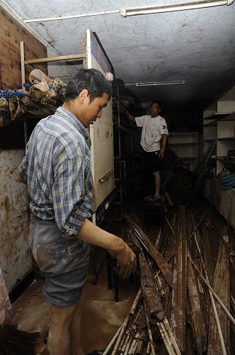 7月20日,洪水消退后,廣安城區(qū)兩名市民正在清理自家被淹的店鋪。四川省廣安市廣安區(qū)洪水水位從19日22時(shí)開始消退后,消退速度逐漸加快,截至20日14時(shí),洪水水位已消退至233.868米,消退了4.31米,據(jù)預(yù)計(jì)到21日凌晨2時(shí)至3時(shí),洪水將消退到警戒水位以下,洪水將全部退出廣安城區(qū)。目前當(dāng)?shù)匾颜归_清淤、消毒殺菌滅害工作。新華社記者 李橋橋 攝