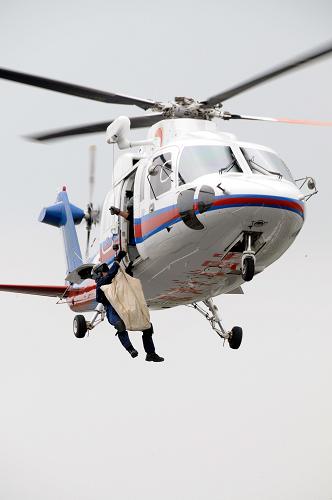 7月22日,交通運輸部北海救助飛行隊S-76直升機趕到模擬事故現(xiàn)場懸停,救援人員攜帶工具從機上降落地面。新華社記者 徐揚 攝