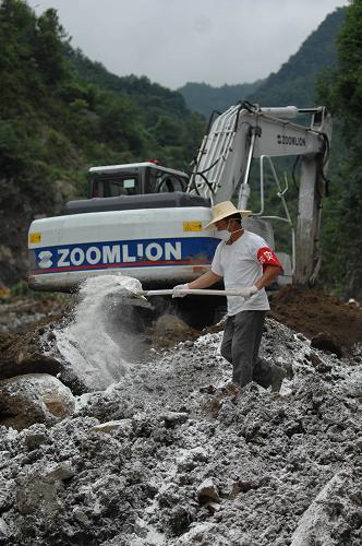 7月23日,在造成29人失蹤的安康市漢濱區(qū)七堰村滑坡現(xiàn)場,一位搶險人員在灑消毒粉。新華社記者 丁海濤 攝