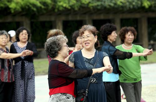 8月26日,在遼寧丹東市鴨綠江公園,人們?cè)谇宄暧倌嗟膹V場(chǎng)上跳健身舞。新華社發(fā)(戚萬(wàn)鵬 攝)