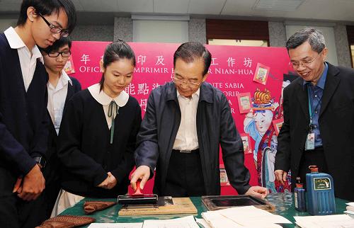 11月14日,國務(wù)院總理溫家寶來到澳門博物館,同在這里參觀學(xué)習(xí)的學(xué)生們親切交流。這是溫家寶與學(xué)生們一起動(dòng)手印制年畫。新華社記者 饒愛民 攝