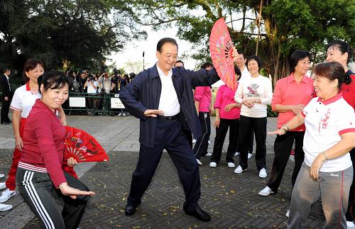 11月14日,國務(wù)院總理溫家寶來到澳門大炮臺花園,同在這里晨練的市民親切交流,一起練習(xí)太極拳并學(xué)練太極扇。新華社記者 饒愛民 攝