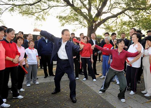 11月14日,國(guó)務(wù)院總理溫家寶來到澳門大炮臺(tái)花園,同在這里晨練的市民親切交流,一起練習(xí)太極拳并學(xué)練太極扇。新華社記者 饒愛民 攝