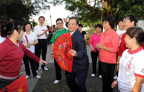 11月14日,國(guó)務(wù)院總理溫家寶來到澳門大炮臺(tái)花園,同在這里晨練的市民親切交流,一起練習(xí)太極拳并學(xué)練太極扇。新華社記者 饒愛民 攝