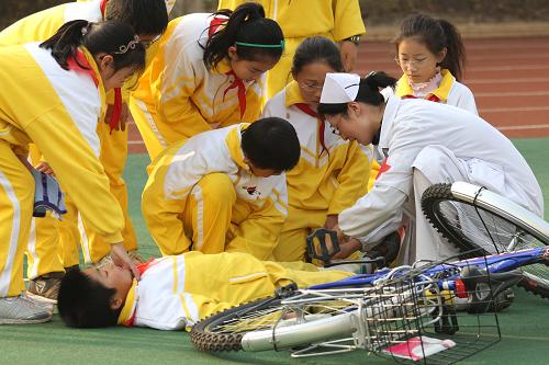 11月29日,在南通第二附屬小學(xué)開展的應(yīng)急聯(lián)合演練活動中,南通中醫(yī)院的醫(yī)護人員指導(dǎo)小營員們在“交通事故現(xiàn)場”進行互救。新華社發(fā)(黃哲 攝)