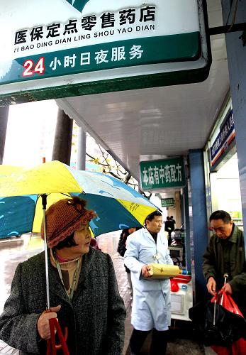12月13日,一名婦女在上海市江蘇路向一家藥店內張望。當日,《上海市實施國家基本藥物制度工作方案(試行)》和《上海市基層醫(yī)療衛(wèi)生機構增補藥物目錄》(2010版)正式發(fā)布,它標志著上海已正式啟動實施國家基本藥物制度。據悉,實施以上方案后,上海的社區(qū)衛(wèi)生服務中心配備使用的藥品全部實施零差率銷售,這將進一步減輕患者醫(yī)藥費用負擔,讓百姓從基本藥物制度的實施中得到實惠。新華社記者 陳飛 攝