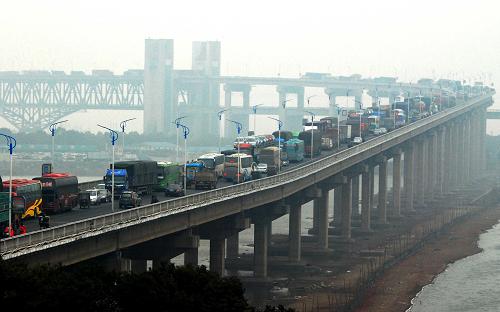 1月27日,在江西九江長江大橋上,車輛排隊等待通行。從1月26日12點至27日12點,九江長江大橋迎來4.1萬輛返程車流,加上1月26日下午,湖北省黃梅縣小池口鎮(zhèn)發(fā)生多起交通事故,致使九江長江大橋及福銀高速昌九段交通擁堵近20小時,其中福銀高速昌九段最長擁堵路段長達20公里。截至發(fā)稿時,上百名交警仍在現(xiàn)場指揮疏堵。新華社發(fā)(胡國林 攝)