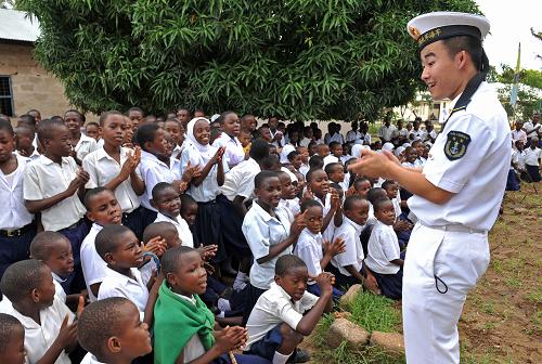3月28日,在坦桑尼亞首都達累斯薩拉姆市的烏夫科尼海軍子弟小學,中國海軍第七批護航編隊“舟山”艦戰(zhàn)士戚江朋與同學們一起做游戲。新華社記者 范軍威 攝