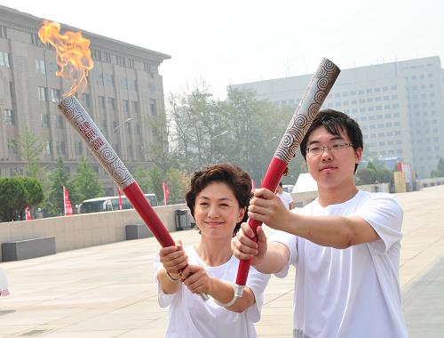 6月9日,北京奧運(yùn)會火炬手海霞(左)手持行健無疆火炬在北京中華世紀(jì)壇與大學(xué)生代表接力。新華社記者 楊光 攝