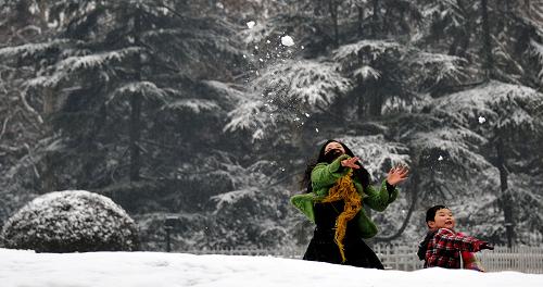 1月3日,一對(duì)母子在湖南長(zhǎng)沙烈士公園內(nèi)玩雪。新華社記者 趙眾志 攝