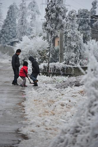 1月4日,貴州開陽縣幾名兒童在家門口鏟除積雪。開陽縣是貴州受凝凍影響最嚴(yán)重的地區(qū)之一,1月2日該縣電線積冰直徑曾達(dá)46毫米。新華社記者 歐東衢 攝