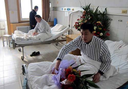 1月5日,在堵截持槍歹徒戰(zhàn)斗中負(fù)傷的泰安市交警支隊(duì)直屬一大隊(duì)副隊(duì)長劉峰(右)和中隊(duì)長趙偉在醫(yī)院治療。新華社記者 朱崢 攝