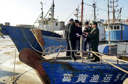 滄州市南排河邊防派出所民警在向漁民發(fā)放有關防范海冰的宣傳材料(1月8日攝)。新華社記者 楊世堯攝